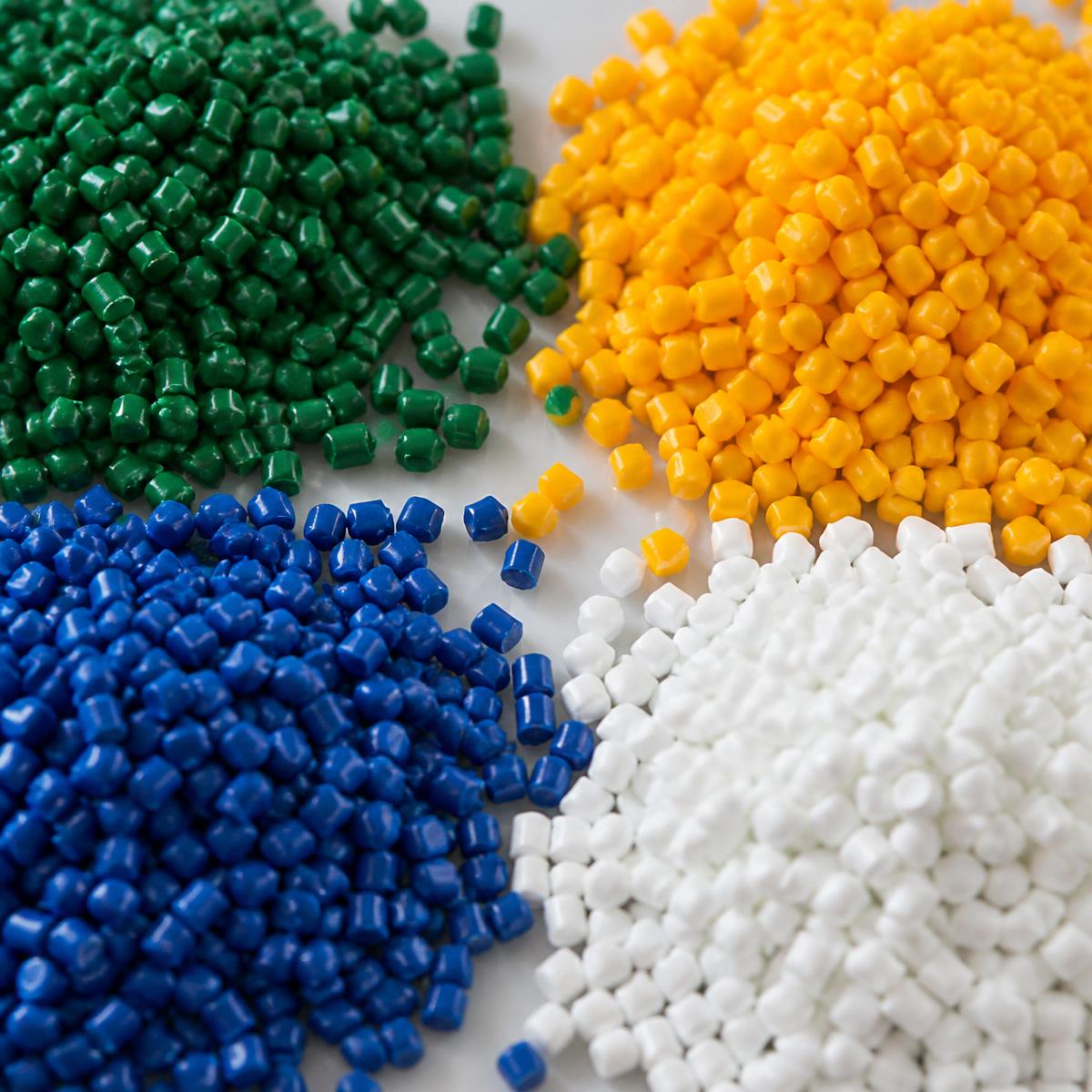 Grânulos plásticos nas cores verde, amarelo, azul e branco separados por pilhas