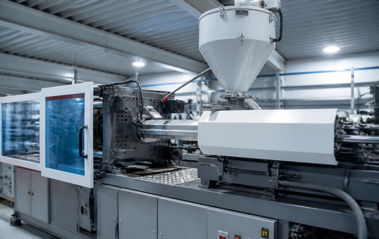 Máquina injetora processando matéria-prima plástica